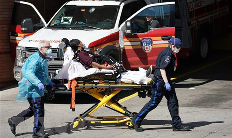 Nhân viên y tế chuyển bệnh nhân COVID-19 tới bệnh viện tại Brooklyn, New York, Mỹ. Ảnh: AFP/TTXVN