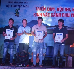 Đ/c Nguyễn Văn Khoa (người thứ 2 từ trái sang) trao giải vàng thể loại cây Bonsai trung cho các nghệ nhân tham gia hội thi. 