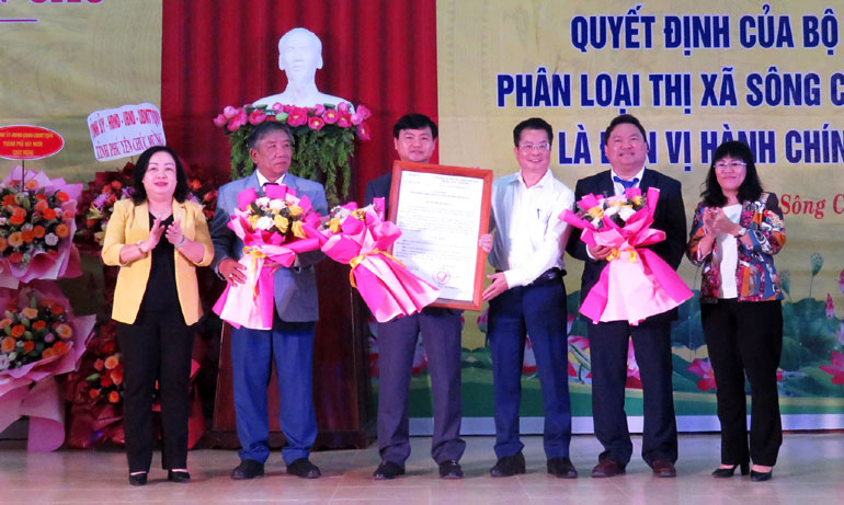 Đồng chí Cao Thị Hòa An (bìa trái); đồng chí Hồ Thị Nguyên Thảo (bìa phải) và ông Nguyễn Hữu Thành (thứ 3 từ phải qua) trao quyết định của Bộ trưởng Nội vụ và tặng hoa chúc mừng lãnh đạo TX Sô