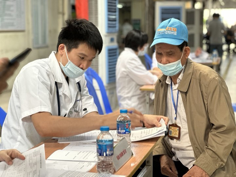 Nhân viên y tế tư vấn khám chữa bệnh cho người dân. Ảnh: Vietnam+