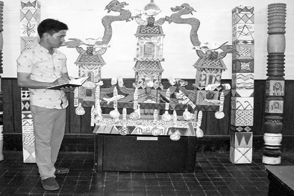 Tác giả, bên mô hình thuyền Ka go, trưng bày tại Bảo tàng tỉnh Khánh Hòa. Ảnh: Mai Thi
