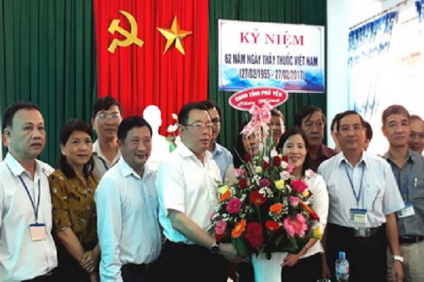 Đồng chí Hoàng Văn Trà tặng hoa chúc mừng Sở Y tế - Ảnh: YÊN LAN