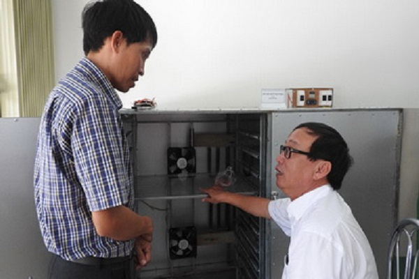 Anh Đặng Xuân Thanh (trái) giới thiệu máy sấy khô thực phẩm - Ảnh: THÁI HÀ