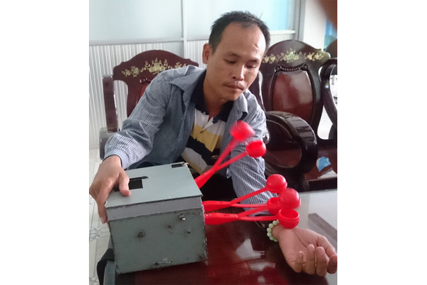 Anh Ngô Văn Thùy và chiếc máy “Đấm lưng” do anh sáng chế.