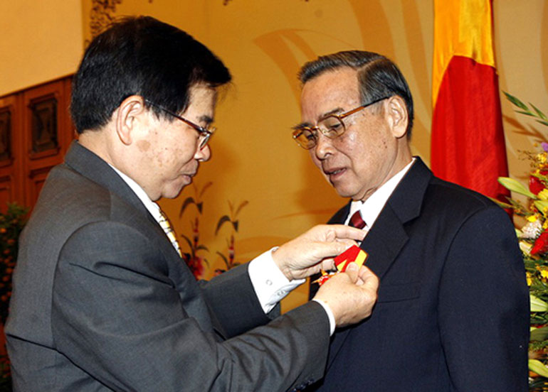 Chủ tịch nước Nguyễn Minh Triết gắn Huân chương Sao Vàng cho nguyên Thủ tướng Phan Văn Khải tại Văn phòng Chính phủ ngày 5/1/2008 - Ảnh: TTXVN