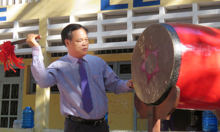 Đồng chí Huỳnh Tấn Việt đánh trống khai giảng tại Trường THPT Nguyễn Huệ - Ảnh: THÚY HẰNG