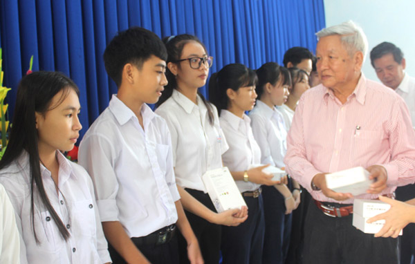 Ông Lê Văn Hữu, Chủ tịch Hội Khuyến học tỉnh Phú Yên trao máy tính bảng cho học sinh nghèo hiếu học - Ảnh: KIM LIÊN
