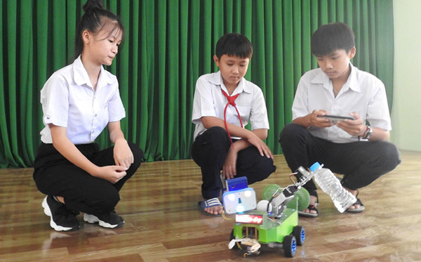 Trần Thị Mỹ Thoai (trái) và Bùi Thành Công (phải), học sinh lớp 9 Trường tiểu học và THCS Lê Quý Đôn (TX Sông Cầu) giới thiệu sản phẩm Smart Family Robot - Ảnh: THÁI HÀ