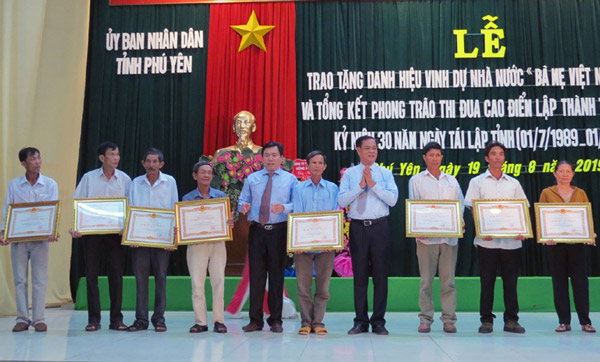 Các đồng chí Huỳnh Tấn Việt và Trần Hữu Thế trao quyết định truy tặng Danh hiệu vinh dự nhà nước Bà mẹ VNAH cho các thân nhân - Ảnh: THÙY THẢO