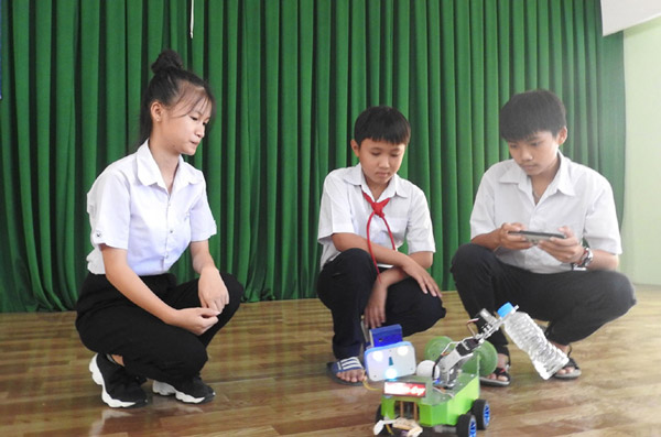 Hai em Trần Thị Mỹ Thoai (bên trái) và Bùi Thành Công (bên phải) - TX Sông Cầu, giới thiệu sản phẩm Smart family robot đạt giải nhì tại cuộc thi Sáng tạo thanh thiếu niên và nhi đồng lần 4 (năm 2019). Ảnh