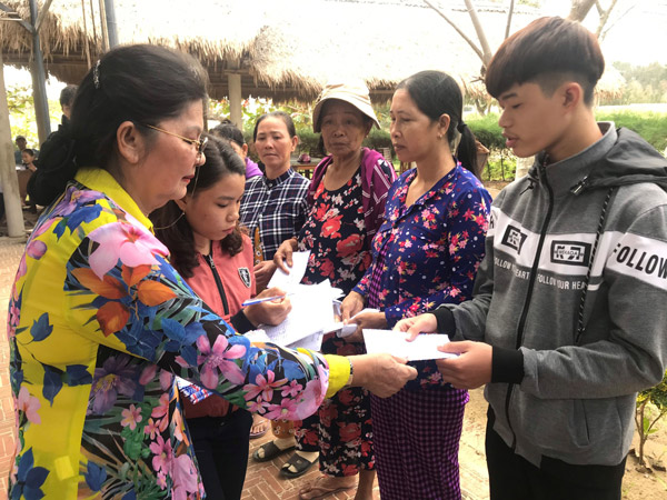 Bà Huỳnh Thị Kim Hương, đại diện Hội Đồng hương Phú Yên tại TP Hồ Chí Minh trao quà Tết cho người dân xã An Chấn - Ảnh: MINH DƯƠNG