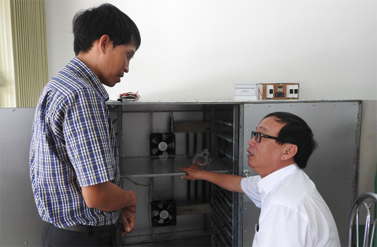 Đặng Xuân Thanh (trái) giới thiệu máy sấy bò một nắng tại Hội thi Sáng tạo kỹ thuật tỉnh Phú Yên lần 7. Ảnh: THÁI HÀ