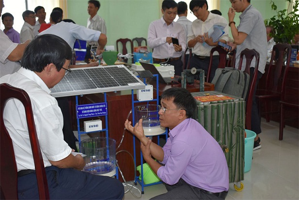 Tác giả Phạm Duy Phượng (phải) giới thiệu mô hình hệ thống bơm nước tự động không dây, sử dụng điện năng lượng mặt trời. Ảnh: HOÀNG HÀ THẾ