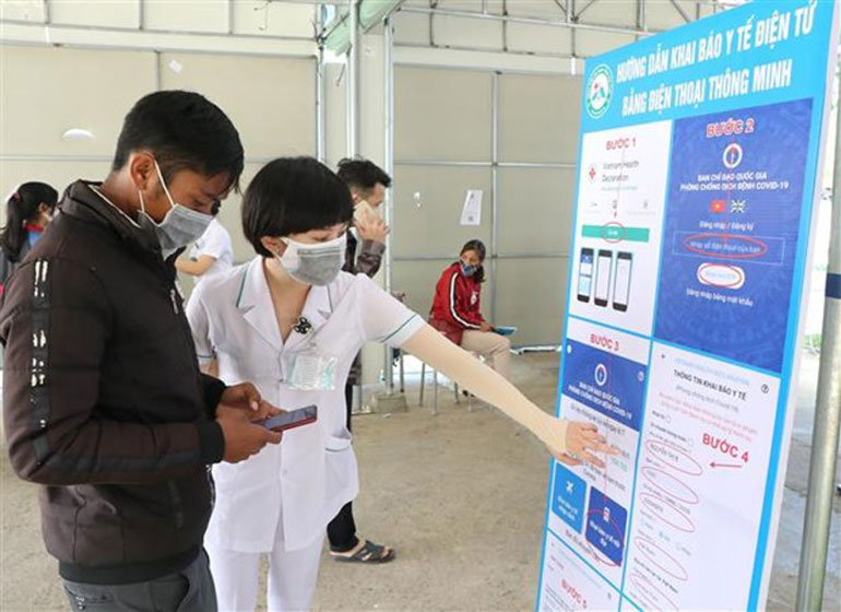 Nhân viên Bệnh viện Đa khoa tỉnh Kon Tum hỗ trợ người dân khai báo y tế và quét mã QR trên ứng dụng VietNam Health Declaration. Ảnh: TTXVN