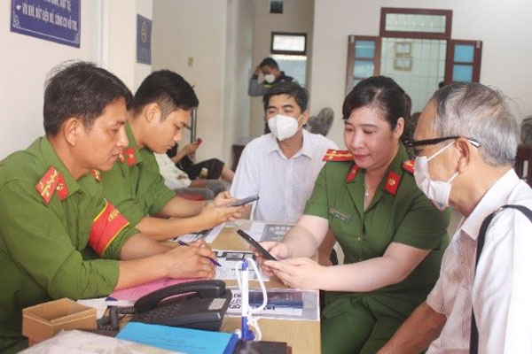 Đoàn viên Chi đoàn Phòng Cảnh sát quản lý hành chính về trật tự xã hội hướng dẫn người dân cài đặt tài khoản ĐDĐT và đăng ký cấp CCCD trực tuyến. Ảnh: THỦY TIÊN