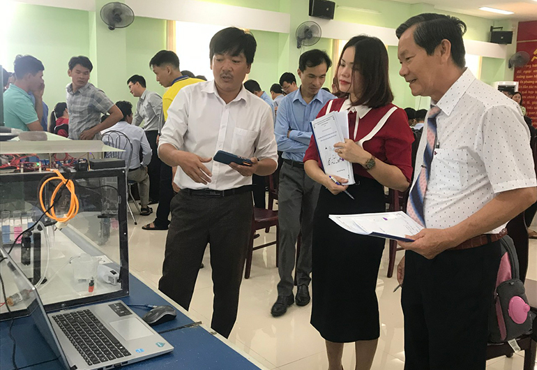 Thầy Nguyễn Thanh Tuấn (bìa trái) thuyết minh giải pháp “Hệ thống thực hành thí nghiệm hóa học tự động, thông minh dành cho học sinh phổ thông” tại Hội thi Sáng tạo kỹ thuật lần thứ 10, năm học 2